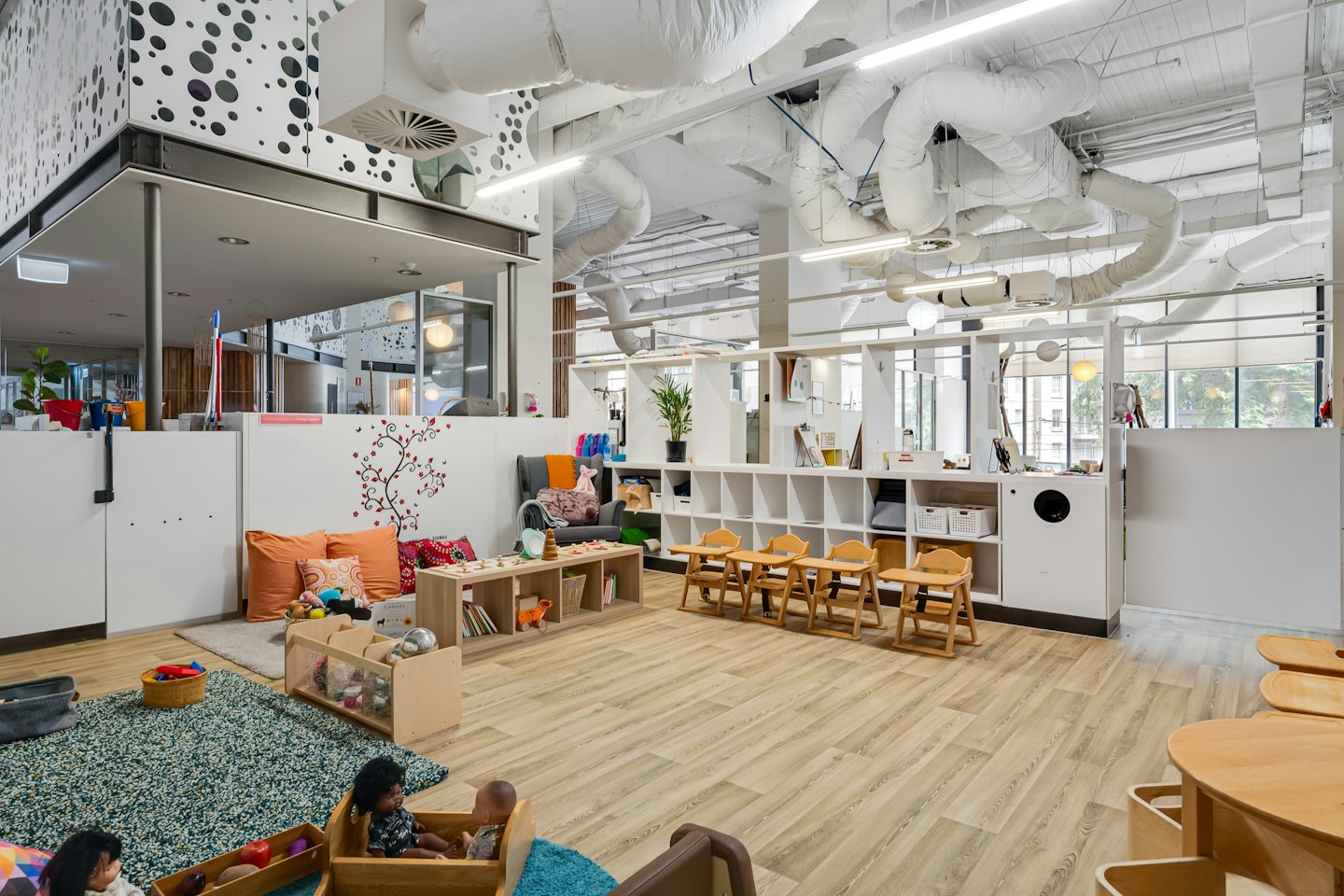 Modern childcare center with organized play areas and wooden furniture.
